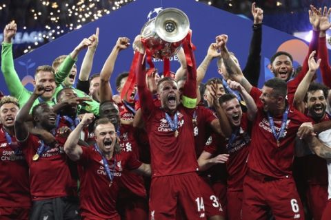 Liverpool's Jordan Henderson lifts the trophy to celebrate with his teammates winning the Champions League final soccer match between Tottenham Hotspur and Liverpool at the Wanda Metropolitano Stadium in Madrid, Saturday, June 1, 2019. (AP Photo/Francisco Seco)