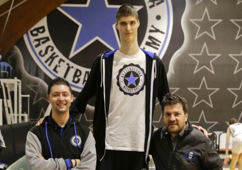 In this Saturday, Dec. 5, 2015, photo, Robert Bobroczkyi, center, poses for a photo with Stellazzurra Basketball Academy general manager Giacomo Rossi, left, and club president Fabio de Mita during an interview in Rome. Standing 7-foot-6 (2.29 meters) at the age of 15, Robert Bobroczkyi is already taller than New York Knicks sensation Kristaps Porzingis, or any other current NBA player. (AP Photo/Andrew Medichini)