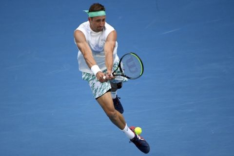 Tennys Sandgren of the U.S. makes a backhand return to Italy's Fabio Fognini during their fourth round singles match at the Australian Open tennis championship in Melbourne, Australia, Sunday, Jan. 26, 2020. (AP Photo/Andy Brownbill)