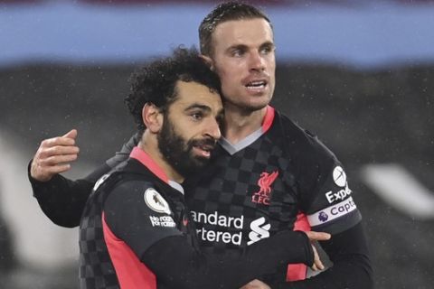 Liverpool's Mohamed Salah, left, celebrates after scoring his side's second goal with Liverpool's Jordan Henderson during the English Premier League match between West Ham and Liverpool at the the London Stadium in London, Sunday, Jan. 31, 2021. (Justin Setterfield/Pool via AP)