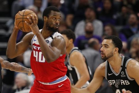 Sacramento Kings forward Harrison Barnes, left, looks to pass the ball as San Antonio Spurs center Trey Lyles, right, defends during the second half of an NBA basketball game in Sacramento, Calif., Saturday, Feb. 8, 2020. The Kings won 122-102. (AP Photo/Rich Pedroncelli)