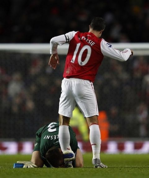 Arsenal goalkeper Wojciech Szczesny (L) kisses Robin Van Persie's left boot after winning their English Premier League soccer match against Everton at the Emirates Stadium in London December 10, 2011.    REUTERS/Eddie Keogh (BRITAIN - Tags: SPORT SOCCER) FOR EDITORIAL USE ONLY. NOT FOR SALE FOR MARKETING OR ADVERTISING CAMPAIGNS. NO USE WITH UNAUTHORIZED AUDIO, VIDEO, DATA, FIXTURE LISTS, CLUB/LEAGUE LOGOS OR "LIVE" SERVICES. ONLINE IN-MATCH USE LIMITED TO 45 IMAGES, NO VIDEO EMULATION. NO USE IN BETTING, GAMES OR SINGLE CLUB/LEAGUE/PLAYER PUBLICATIONS