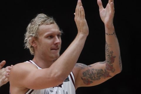 Latvia's Janis Timma applauds the crowd after winning 73-66 in the EuroBasket European Basketball Championships match, round of sixteen, against Slovenia, on Saturday, Sept. 12, 2015 in Lille, northern France. (AP Photo/Michel Spingler)