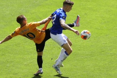 Wolverhampton Wanderers' Daniel Podence, left, duels for the ball with Everton's Lucas Digne during the English Premier League soccer match between Watford and Everton at the Molineux Stadium in Wolverhampton, England, Sunday, July 12, 2020. (Richard Heathcote/Pool via AP)