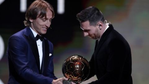 Barcelona's soccer player Lionel Messi, right, receives his sixth golden ball from Real Madrid's Lucas Modric during the Golden Ball award ceremony in Paris, Monday, Dec. 2, 2019. (AP Photo/Francois Mori)