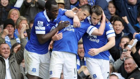 Everton's Kevin Mirallas centre, celebrates with team-mates Leighton Baines right, and Romelu Lukaku left, after he scored the second goal of the game for his side during their English Premier League soccer match against Manchester United at Goodison Park in Liverpool, England, Sunday April 20, 2014. (AP Photo/Clint Hughes)  