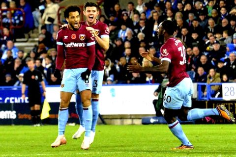 West Ham United's Felipe Anderson, left, celebrates with teammates scoring his side's first goal of the game during the English Premier League soccer match between Huddersfield Town and West Ham at the John Smith's Stadium, Huddersfield, England, Saturday, Nov. 10, 2018. (Dave Howarth/PA via AP)