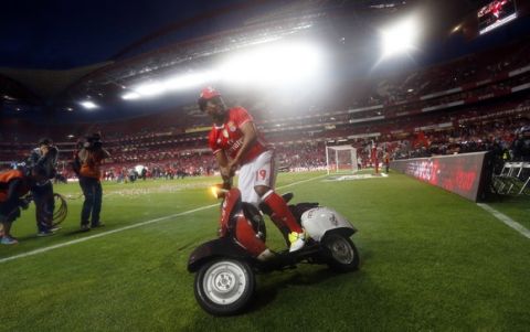 Benfica's Eliseu rides a scooter around on the pitch celebrating at the end of the Portuguese league soccer match between Benfica and Vitoria de Guimaraes at the Luz stadium in Lisbon, Saturday, May 13, 2017. Benfica won the match 5-0 to clinch the championship title with one round left to play. (AP Photo/Pedro Rocha)