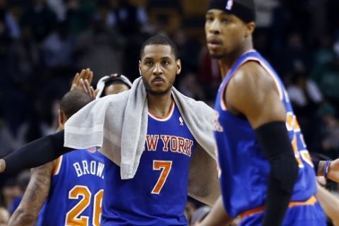 New York Knicks forward Carmelo Anthony (7) reaches for teammates, including guard Toure' Murry, right, to celebrate their 116-92 victory over the Boston Celtics in an NBA basketball game in Boston, Wednesday, March 12, 2014. (AP Photo/Elise Amendola)