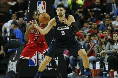 Orlando Magic's Nikola Vucevic, right, is defended by Chicago Bulls' Justin Holiday in the first half of their regular-season NBA basketball game in Mexico City, Thursday, Dec. 13, 2018. (AP Photo/Rebecca Blackwell)