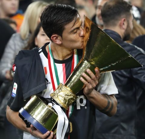 Juventus' Paulo Dybala kisses the Serie A soccer title trophy at the Allianz Stadium, in Turin, Italy, Sunday, May 19, 2019. (AP Photo/Antonio Calanni)
