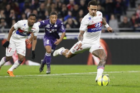 Lyon's Memphis Depay kicks the ball to score his second goal during their French League One soccer match against Toulouse in Decines, near Lyon, central France, Sunday, April 1, 2018. (AP Photo/Laurent Cipriani)