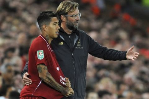 Liverpool manager Juergen Klopp, right, gives instructions to Roberto Firmino during the English League Cup soccer match between Liverpool and Chelsea at Anfield stadium in Liverpool, England, Wednesday, Sept. 26, 2018. (AP Photo/Rui Vieira)