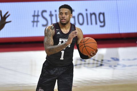 Texas A&M guard Savion Flagg (1) looks for an open man as he plays against Arkansas during the second half of an NCAA college basketball game in Fayetteville, Ark., Saturday, March 6, 2021. (AP Photo/Michael Woods)