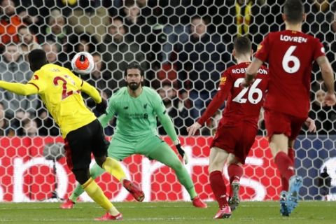 Liverpool's goalkeeper Alisson makes a save in front of Watford's Ismaila Sarr, left, during the English Premier League soccer match between Watford and Liverpool at Vicarage Road stadium, in Watford, England, Saturday, Feb. 29, 2020. (AP Photo/Alastair Grant)