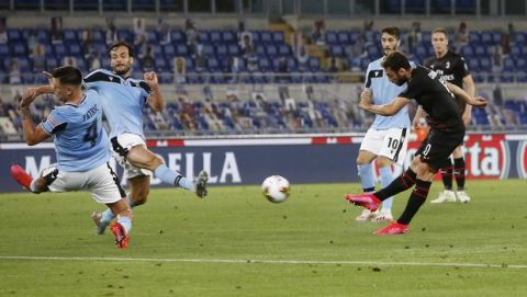 AC Milan's Hakan Calhanoglu, right, scores his side's opening goal during the Serie A soccer match between Lazio and AC Milan at the Rome Olympic stadium, Saturday, July 4, 2020. (AP Photo/Riccardo De Luca)