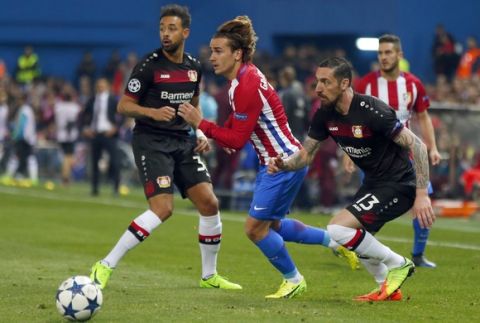 Atletico's Antoine Griezmann, center, is challenged by Leverkusen's Roberto Hilbert, right, during the Champions League round of 16 second leg soccer match between Atletico Madrid and Bayer Leverkusen at the Vicente Calderon stadium in Madrid, Spain, Wednesday, March 15, 2017. (AP Photo/Daniel Ochoa de Olza)