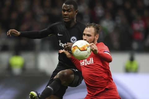 Frankfurt's Evan N'Dicka, left, and Salzburg's Andreas Ulmer battle for the ball during the Europa League round of 32 first leg soccer match between Eintracht Frankfurt and FC Red Bull Salzburg at the Commerzbank-Arena in Frankfurt, Germany, Thursday, Feb. 20, 2020. (Arne Dedert/dpa via AP)