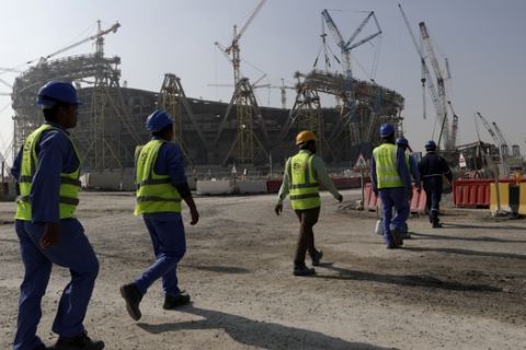 Workers walk to the Lusail Stadium, one of the 2022 World Cup stadiums, in Lusail, Qatar, Friday, Dec. 20, 2019. Construction is underway to complete Lusail's 80,000-seat venue for the opening game and final in a city that didn't exist when Qatar won the FIFA vote in 2010. (AP Photo/Hassan Ammar)