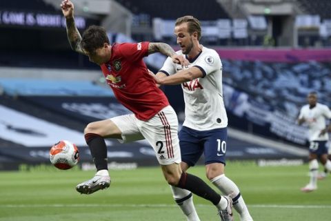 Manchester United's Victor Lindelof, left, and Tottenham's Harry Kane battle for the ball during the English Premier League soccer match between Tottenham Hotspur and Manchester United at Tottenham Hotspur Stadium in London, England, Friday, June 19, 2020. (AP Photo/Glyn Kirk, Pool)