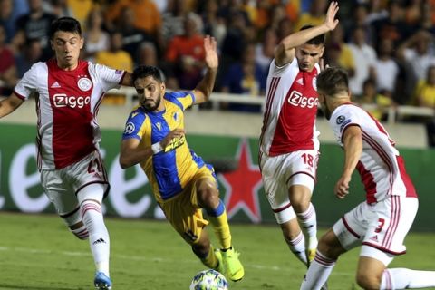Ajax's Joel Veltman, right, Razvan Marin, second right, and Lisandro Martinez, left, challenge APOEL's Musa Suleiman, second left, during the Champions League qualifying playoff first leg soccer match at GSP stadium in Nicosia, Cyprus, Tuesday, Aug. 20, 2019. (AP Photo/Philippos Christou)