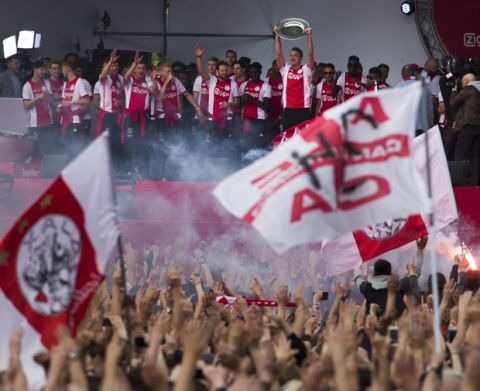 Ajax captain Matthijs de Ligt holds the trophy as he celebrates with teammates after clinching the Dutch Premier League soccer title in Amsterdam, Netherlands, Thursday, May 16, 2019. (AP Photo/Peter Dejong)