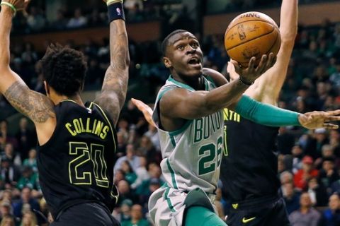 Boston Celtics' Jabari Bird (26) drives for the basket past Atlanta Hawks' John Collins (20) during the fourth quarter of an NBA basketball game in Boston, Sunday, April 8, 2018. (AP Photo/Michael Dwyer)