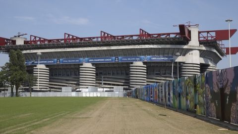 A giant mural, including a black and white interpretation of 1930's Italian player Giuseppe Meazza, is painted along a wall leading towards the San Siro stadium, which officially is called the Giuseppe Meazza stadium, in Milan, Italy, Tuesday, May 17, 2016. The Champions League final between Real Madrid and Atletico Madrid will be held at the legendary soccer stadium of AC and Inter Milan, on Saturday, May 28, 2016.