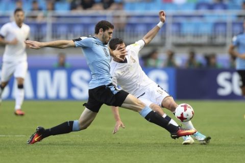 Uruguay's Agustin Rogel, left, fights for the ball against Italy's Andrea Favilli during the play-off for third place match of the FIFA U-20 World Cup Korea 2017 at Suwon World Cup Stadium in Suwon, South Korea, Sunday, June 11, 2017. (AP Photo/Lee Jin-man)