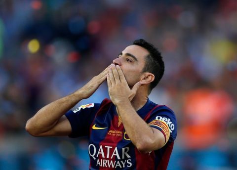 FC Barcelona's Xavi Hernandez blows a kiss to supporters after winning the Spanish League title, at the end of their Spanish La Liga last round soccer match against Deportivo Coruna at the Camp Nou stadium in Barcelona, Spain, Saturday, May 23, 2015. Hernandez says he will leave the Catalan club after 17 trophy-laden seasons in which he set club records for appearances and titles won. (AP Photo/Manu Fernandez)