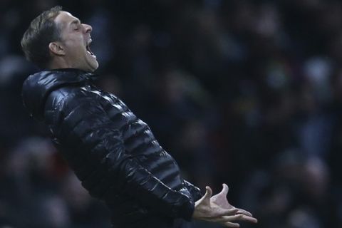 Paris Saint Germain's coach Thomas Tuchel reacts after Paris Saint Germain's Dani Alves takes a direct free kick during the Champions League round of 16 soccer match between Manchester United and Paris Saint Germain at Old Trafford stadium in Manchester, England, Tuesday, Feb. 12,2019.(AP Photo/Dave Thompson)