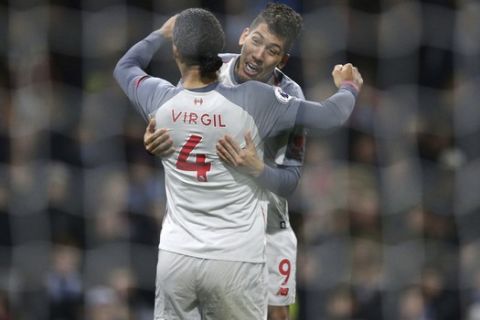 Liverpool's Roberto Firmino celebrates scoring his side's second goal of the game with team-mate Virgil van Dijk, during their English Premier League soccer match at Turf Moor in Burnley, England, Wednesday Dec. 5, 2018. (Nigel French/PA via AP)