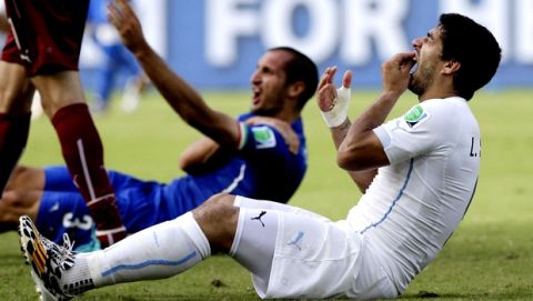 FILE - In this June 24, 2014, file photo,Uruguay's Luis Suarez holds his teeth after running into Italy's Giorgio Chiellini's shoulder during the group D World Cup soccer match between Italy and Uruguay at the Arena das Dunas in Natal, Brazil. (AP Photo/Ricardo Mazalan, File)