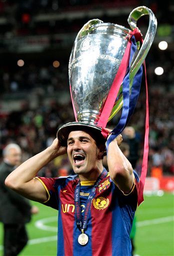 FILE - In this May 28, 2011 file photo, Barcelona's David Villa celebrates with the trophy after winning the Champions League final soccer match against Manchester United at Wembley Stadium, London. Atletico Madrid today won the race to sign David Villa from Barcelona after both clubs confirmed an agreement has been reached in principle for the transfer of Spain's record goal scorer. (AP Photo/Jon Super, File)