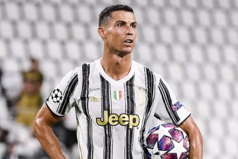 Juventus' Cristiano Ronaldo holds the ball during the Champions League round of 16 second leg, soccer match between Juventus and Lyon at the Allianz stadium in Turin, Italy, Friday, Aug. 7, 2020. (Marco Alpozzi/LaPresse via AP)