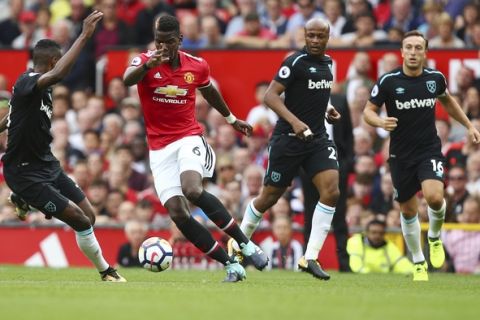 Manchester United's Paul Pogba, 2nd left, takes on the West Ham United defence during the English Premier League soccer match between Manchester United and West Ham United at Old Trafford in Manchester, England, Sunday, Aug. 13, 2017. (AP Photo/Dave Thompson)
