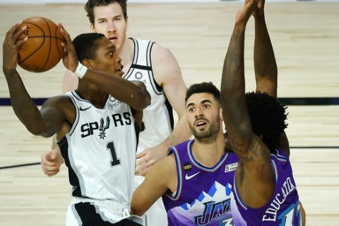 San Antonio Spurs' Lonnie Walker IV (1) drives the basket against Utah Jazz's Georges Niang, center, Ed Davis, right, during the first half of an NBA basketball game Friday, Aug. 7, 2020, in Lake Buena Vista, Fla. (Kevin C. Cox/Pool Photo via AP)