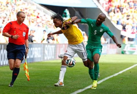 BRASILIA, BRAZIL - JUNE 19: Didier Zokora of the Ivory Coast competes for the ball with Juan Guillermo Cuadrado of Colombia during the 2014 FIFA World Cup Brazil Group C match between Colombia and Cote D'Ivoire at Estadio Nacional on June 19, 2014 in Brasilia, Brazil.  (Photo by Gabriel Rossi/Getty Images)