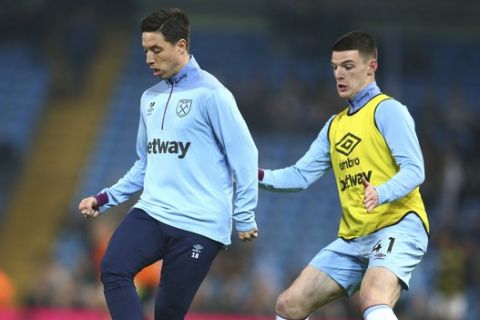 West Ham's Samir Nasri, left, and West Ham's Declan Rice warm up prior to the English Premier League soccer match between Manchester City and West Ham United at Etihad stadium in Manchester, England, Wednesday, Feb. 27, 2019. (AP Photo/Dave Thompson)