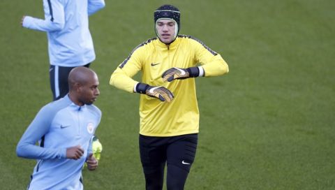Manchester City goalkeeper Ederson wears a protective helmet during the training session at the City Football Academy, Manchester, England, Tuesday, Sept. 12, 2017.  (Martin Rickett/PA via AP)