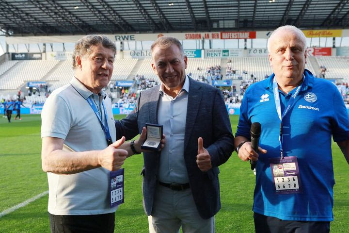 Legends 2004 – UEFA All Stars: Ο Βρούτσης συνεχάρη τον Ρεχάγκελ και του έκανε δώρο ένα συλλεκτικό νόμισμα εκ μέρους της Ελληνικής Κυβέρνησης