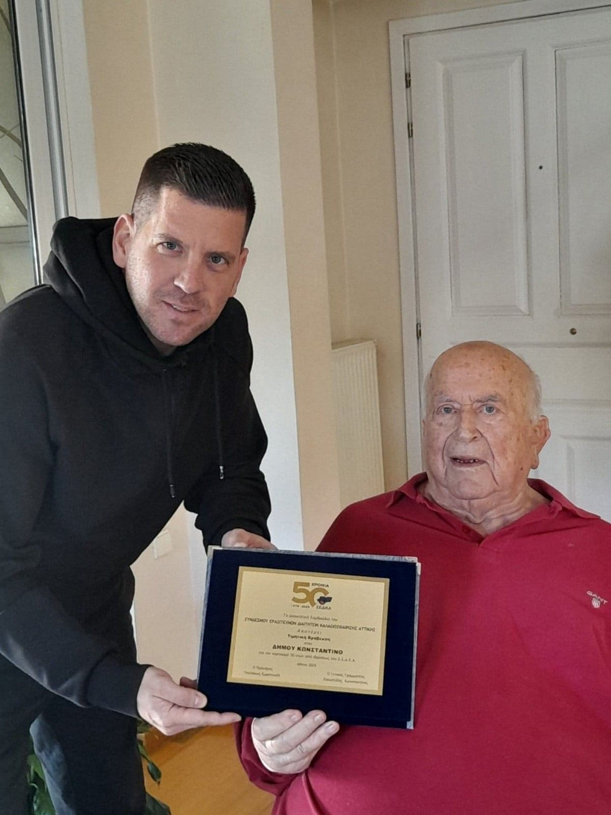 Ο Μάνος Τσολάκος δίνει τιμητική πλακέτα στον Κώστα Δήμου