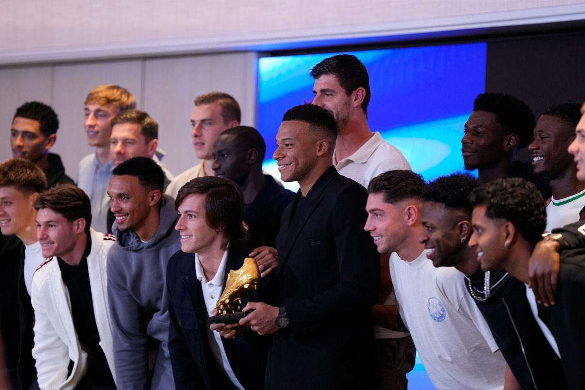 Ο Εμπαπέ κρατάει με υπερηφάνεια το βραβείο του περιστοιχισμένος από τους συμπαίκτες του στην Ρεάλ