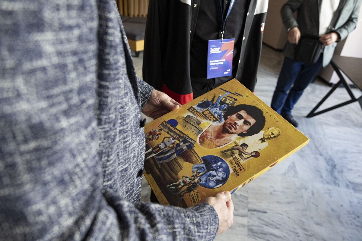 Ο Νίκος Γκάλης κρατάει στα χέρια του τον καμβά με την προσωπογραφία του